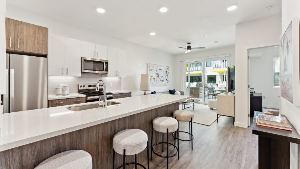 a kitchen with white cabinets and stainless steel appliances at The Blue Eastline